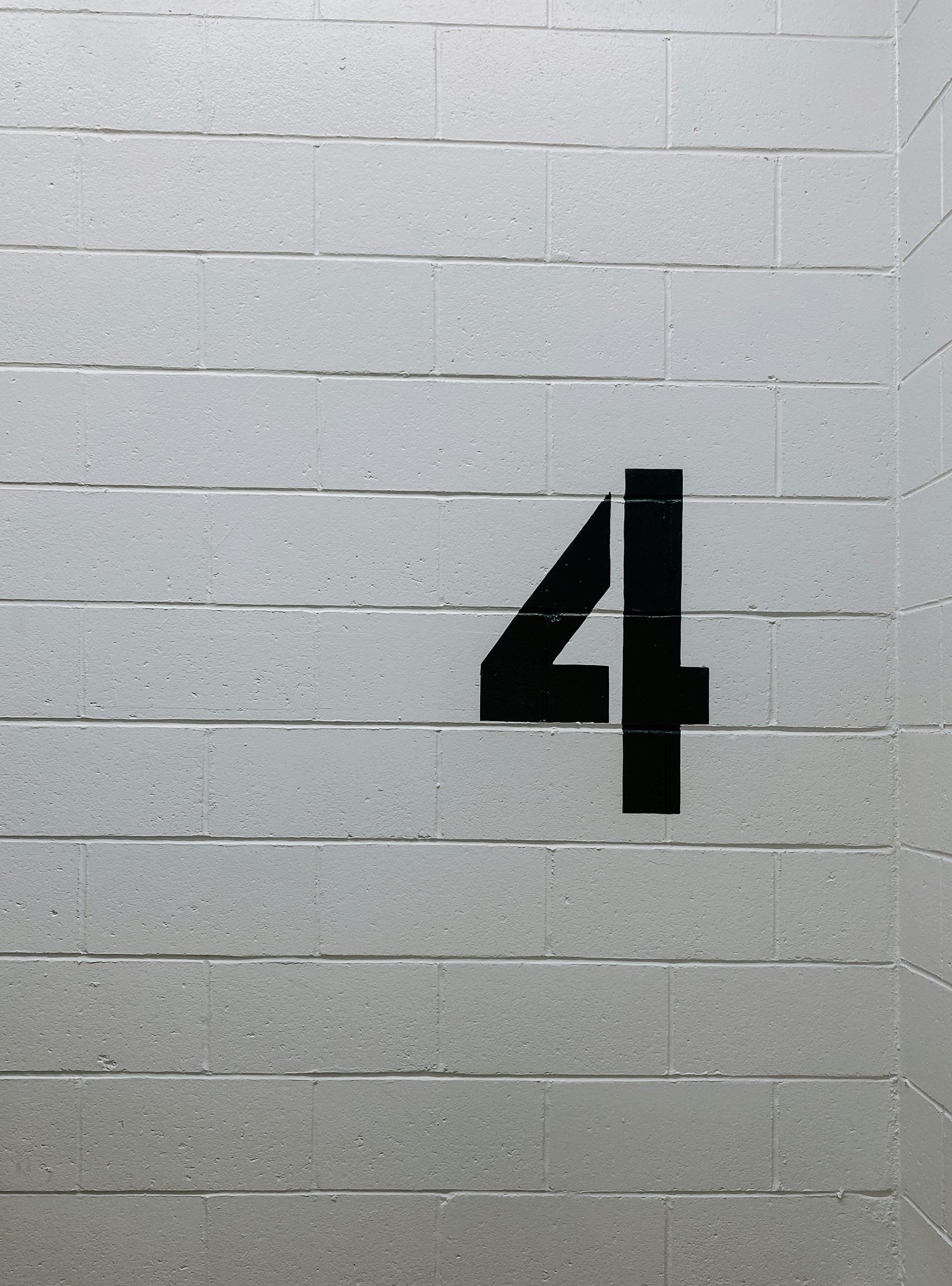 white brick wall with the number 4 painted on it