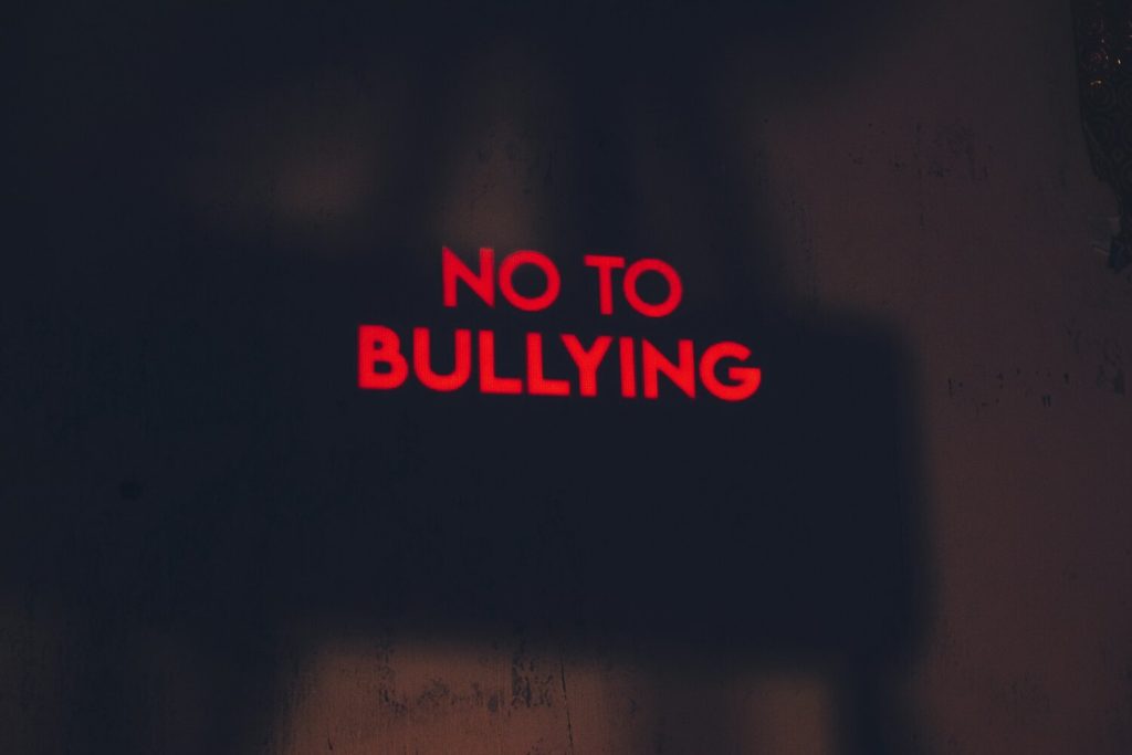 black background with red neon sign that says no to bullying