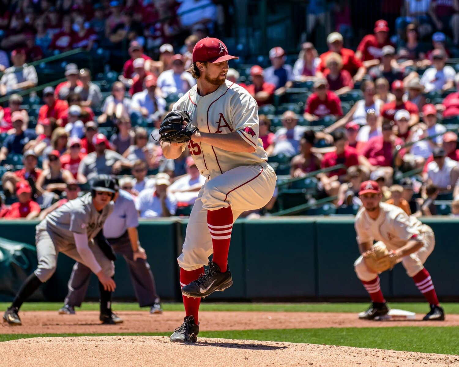 baseball pitcher with team and crowd behind him