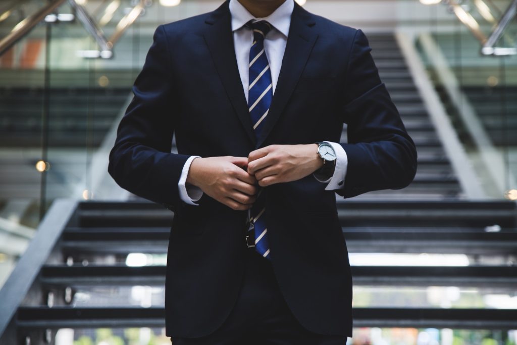 man buttoning up his suit jacket