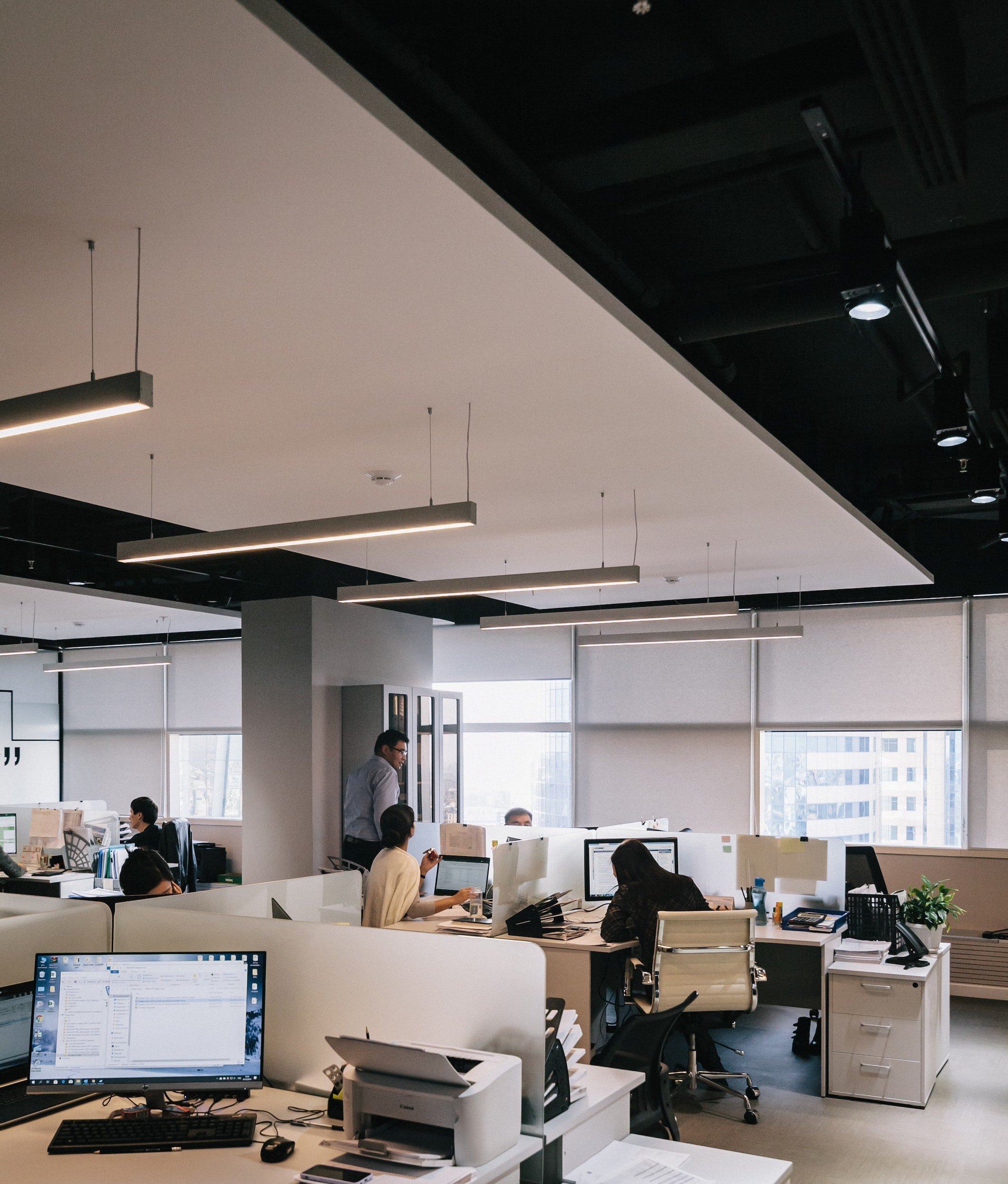 many people sitting in conference room at desks, doing work