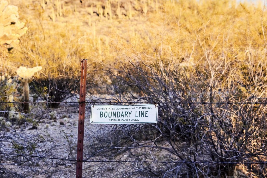 barbed wire fence with boundary line sign