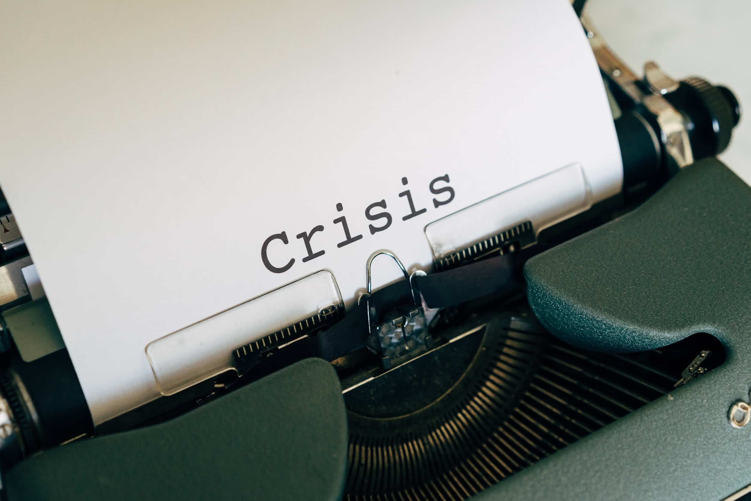 typewriter with peace of paper with crisis typed on it