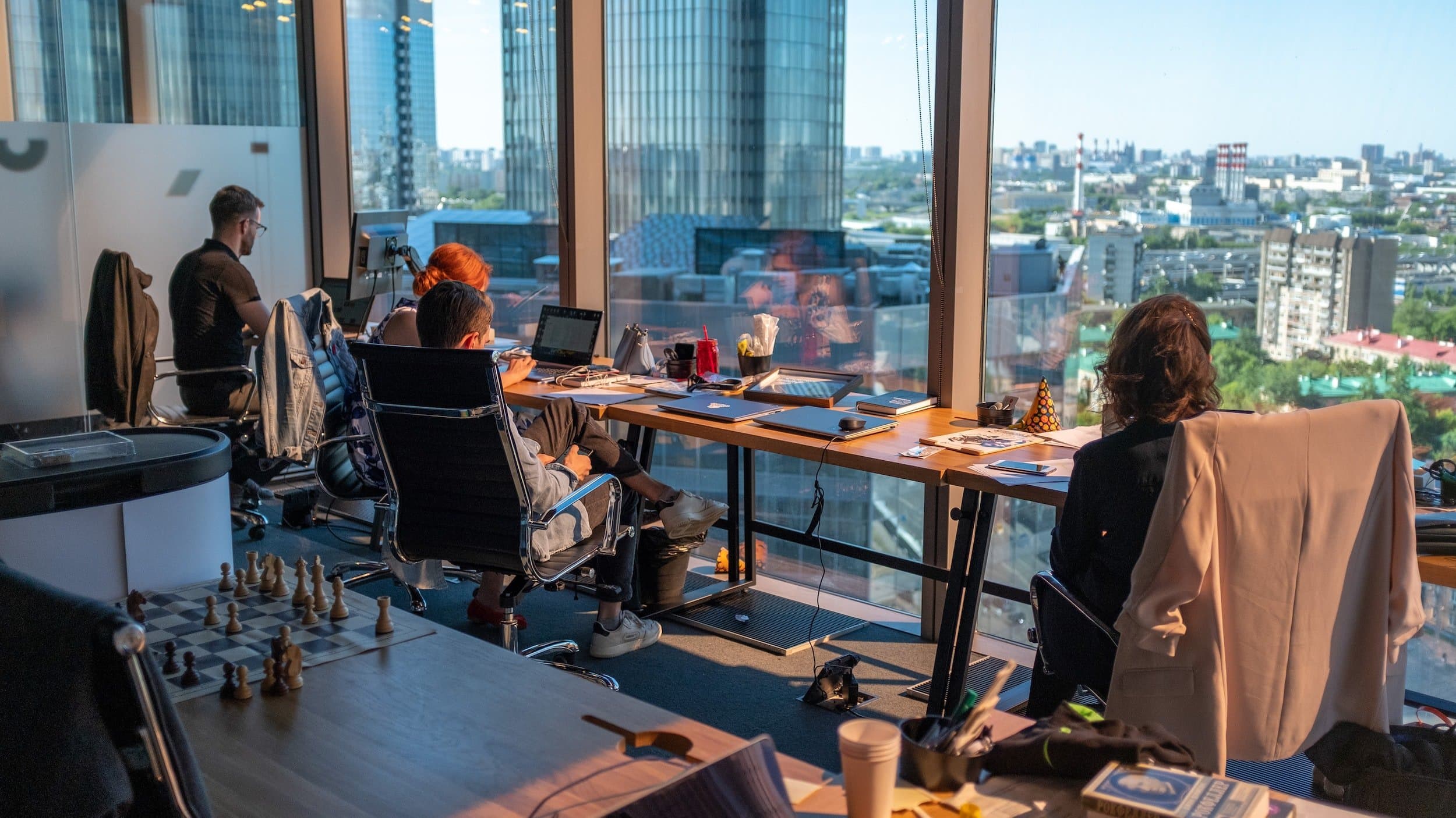 employees working on computers looking through big windows in high rise office