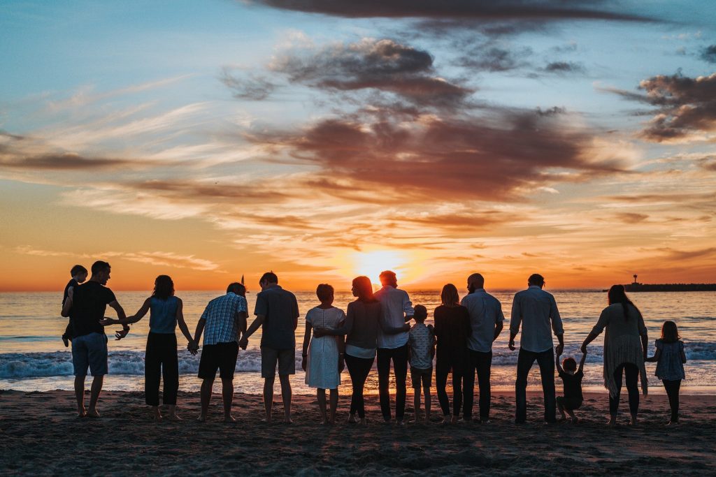 group of people on beach with sunset